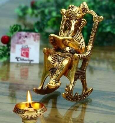 Golden Lord Ganesha Statue Sitting On A Rocking Chair And Reading Ramayan Showpiece Mystical9